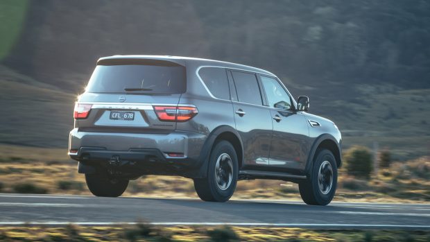 Rear like minded three quarter spy of a 2023 Nissan Patrol Warrior painted in gray on a nation road